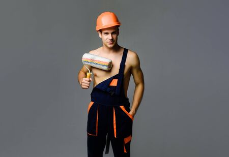 Smiling painter worker man. Painter contractor. Room painting job. Painter in overalls with painting...
