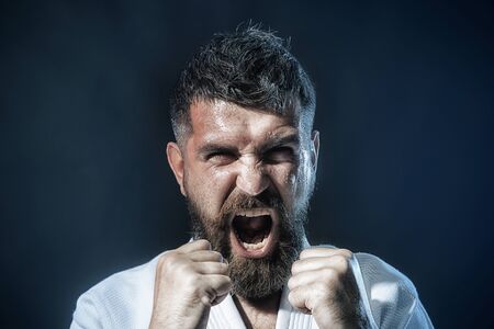 Man practicing karate martial art. Sportsman exercising karate martial art combat, self defense. Bearded man in traditional kimono practicing karate, martial arts, mixed martial arts, MMA, kick boxingの写真素材