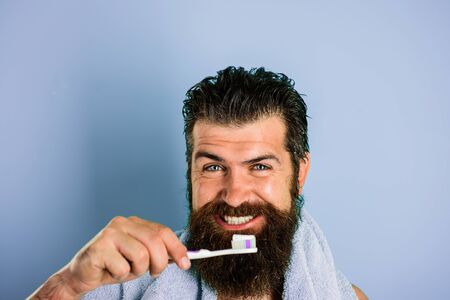 Bearded man brushing teeth. Whitening teeth. Tooth brush. Tooth paste. Morning treatments. Morning routine. Health care. Oral care. Dental hygiene. Cleaning teeth.の写真素材