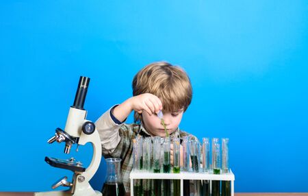 Chemistry. Science. Experiment. Education. Study. Smart boy working with test tubes and microscope....