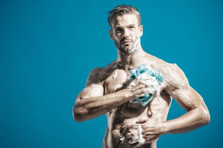Body care, skin care, cleaning concept. Male taking shower in bathroom. Sexy man with naked body washing with sponge. Muscular man in shower. Morning hygiene. Handsome bearded man washing in showerの写真素材