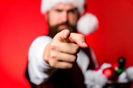 Santa points at camera. Bearded man points at camera. Smiling man in Santa costume points at camera. Christmas promotion concept. Sale. Discount. Selective focus.の写真素材