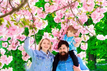 Spring fashion family in spring garden. Springtime. Summertime. Happy couple in flowering trees....
