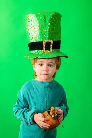 Patrick's Day. Green top hat. Boy in green hat holds pot with gold. Leprechaun. Green hat with clover. Saint Patrick's Day. Traditions of Saint Patrick Day. Sale. Discount. March. Pot with gold.の写真素材
