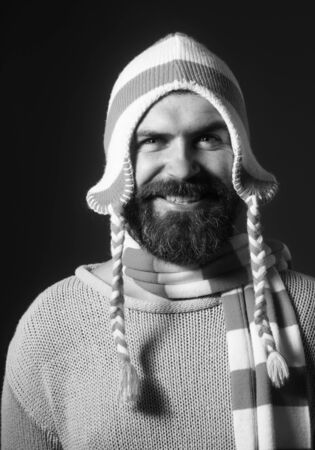 Autumn or winter fashion. Fashionable demi-season clothing. Stylish man wrapped in scarf. Handsome bearded man wearing winter hat and scarf. People, lifestyle, seasons, fashion and clothing conceptの写真素材