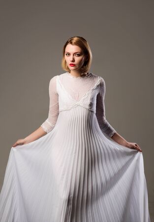 Retro blonde lady wearing fashionable white dress. Beauty, fashion.の写真素材