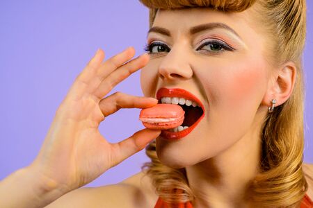 Pastry macaroon. Girl eat tasty macaroon cookies. Cooking, confectionery, food and baking concept. Traditional french colorful macaroons. Sweet meringue-based confection. Woman with delicacy macaroon.の写真素材