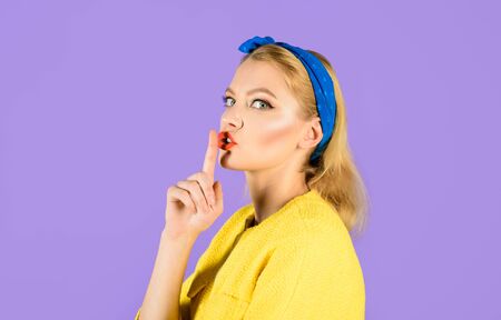 Hush. Woman having secret holds finger on lips, shows shh sign. Attractive woman making gesture silence.の写真素材