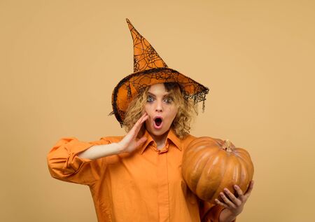 Halloween holidays. 31 October. Halloween costume for party. Woman in witch hat with pumpkin. Surprised woman in witch halloween costume with jack o lantern. Girl witch with pumpkin. Happy Halloweenの写真素材
