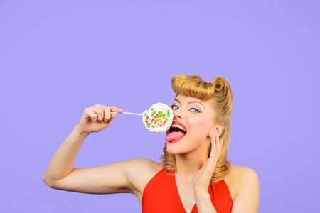 Lollipop. Sweet food. Sweets. Dessert. Happy woman licks lollipop. Pin up model with lollipop in hand. Sexy girl with colourful candy. Candy store. Candy shop. Candy bar.の写真素材
