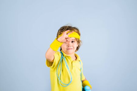 Sport lifestyle. Child sportsman show ok sign. Gym workout. Success. Childhood activity. Fitness, health and energy. Sport. Fitness kid in sportwear. Boy with jump rope and dumbbells. Sport equipmentの写真素材
