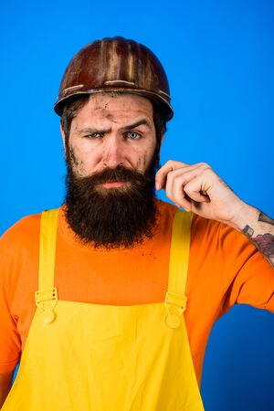 Bearded man in overalls and construction helmet. Mechanical worker. Industrial worker. Construction worker in hardhat. Business, building, industry, technology. Builder in hard hat. Man builderの写真素材