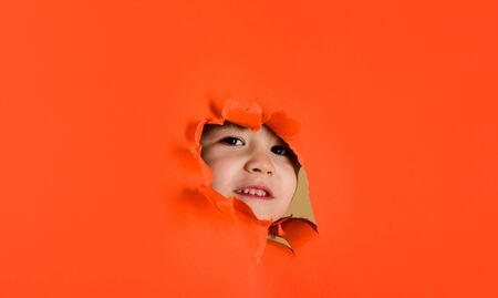 Boy looking through paper. Kid. Boy looking through paper. Season sale. Breaking paper. Sale. Discount. Season sales. Kids. Advertising. Banner. Happy childhood. Black fridayの写真素材