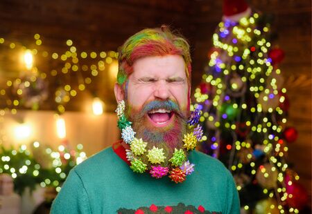 Decorated beard. Cheerful bearded man with decorated beard. New year party. Bearded man with decorated beard. Christmas decoration. Christmas holidays. Christmas beard decorations. Winter holidaysの写真素材