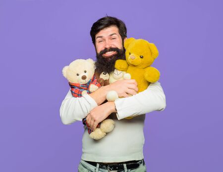 Holiday. Celebration. Happy man holds Teddy bear plush toy. Smiling man hugs teddy bear. Birthday or anniversary. Bearded man with plush toy. Teddy bear. Man with fluffy teddy bear. Gift and presentの写真素材