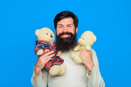 Bearded man with plush toy. Teddy bear. Smiling man holds Teddy bears plush toy. Birthday or anniversary. Gift and present. Holiday. Celebration. Happy man with teddy bear. Man with fluffy teddy bearの写真素材