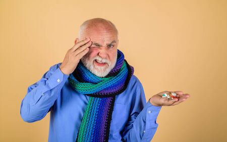 Man taking pills. Migraine. Headache. Sore throat. Treatment. Pharmaceutical drug. Pain. Old man...
