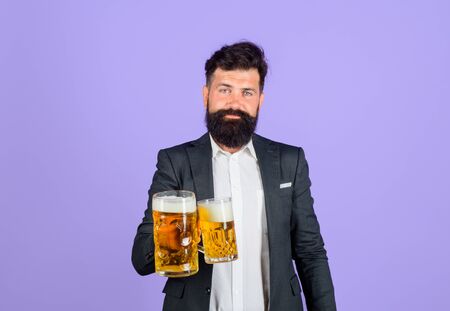 Stylish man drinking beer of glass. Beer pub. Man holds cup of beer with foam. Alcohol. Lager and...