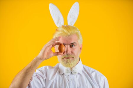 Happy Easter. Man with rabbit ears holds Easter egg. Man in bunny ears holds Easter egg. Rabbit man....