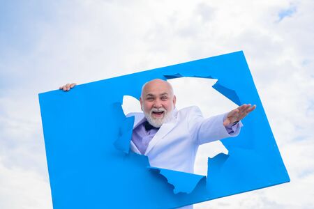 Man through paper. Happy old bearded man through hole in board. Man in suit.Through paper....