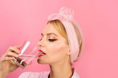 Woman drinking water in morning. Drinking water concept. Young woman drinking water. Weight loss. Healthy lifestyle, diet, healthy food. Health care concept. Young pin up girl drinking glass of waterの写真素材