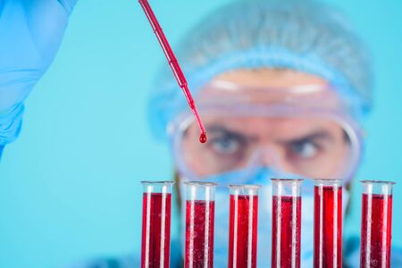 Scientist with test tubes with blood sample making research.Laboratory technician with blood test tube. Male doctor analyzing blood sample in clinic. Science, chemistry, biology and medicine conceptの写真素材