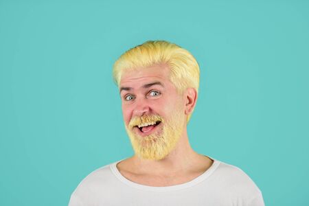 Barbershop. Modern handsome man with blonde dyed hair. Eccentric man with dyed hair. Blond hipster guy. Handsome man with stylish haircut. Bearded man with dyed blonde hair. Coloring of men's hairの写真素材