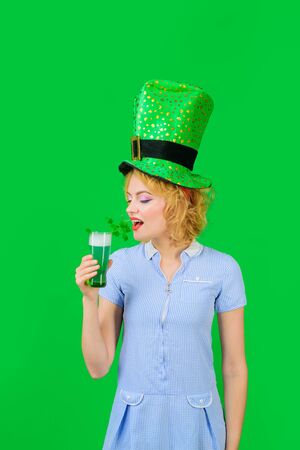 Saint Patricks day or october festival. Beautiful girl in green leprechaun hat drinking green beer. Woman celebrating St Patrick's Day with beer. St Patrick's Day celebration. Patrick Day pub partyの写真素材