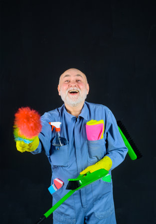 House cleaning. Broom. Old man with cleaning equipment. Professional cleaning. Cleaning service. Clean up. Clearing tools. Household. Housekeeping. Besom. Rag. Dust brushの写真素材