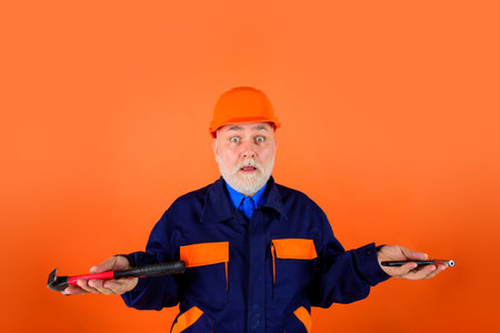 Builder with repair tools. Building. Industry. Old man in construction helmet. Engineers working. Repairment. Portrait mechanical worker. Construction worker in hardhat. Repair toolsの写真素材
