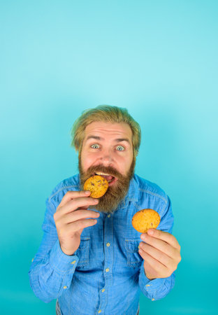 Cookie. Biscuit. Biscuits. Sweet snack. Man eats cookie. Homemade cookies. Taste of childhood. Bearded man with cookies. Breakfast or lunch. Sweet cookies. Bakeryの写真素材