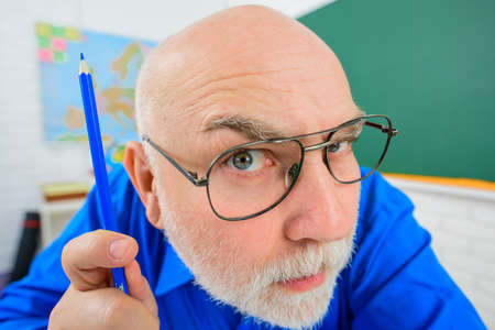 Back to school. September 1. Serious teacher. Learning, education, school concept. Teacher prepares lessons in classroom. Teacher with pencil. Happy teacher in classroom. Teachers dayの写真素材