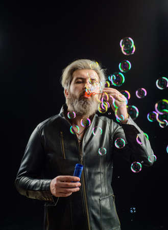 Soap bubbles. Play with bubbles. Bearded man blowing soap bubbles. Happiness. Good mood. Childhood