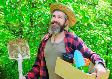Happy farmer in spring garden. Gardener in Eco-farm with gardening tools planting. Man with shovel.