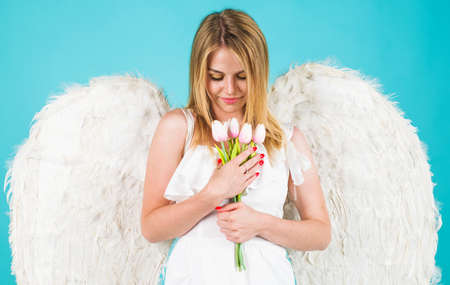 Valentines girl with flowers. Angel woman with white wings. Valentine day cupid.の写真素材