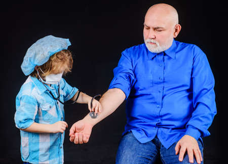 Doctor game. Family playing in doctor and patient. Child boy playing with grandfather. Kid in...
