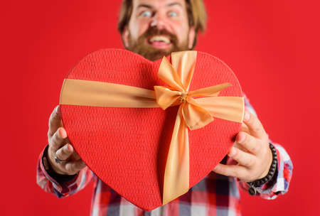 Valentines Day. Heart shape. Present with love. Man with red gift. Happy holiday celebration. Selective focus.の写真素材