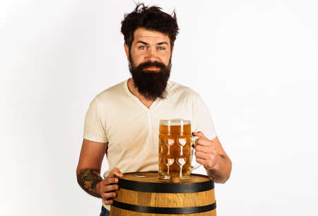 Bearded man with Wooden barrel and glass of beer. Oktoberfest, drink, alcohol.の写真素材