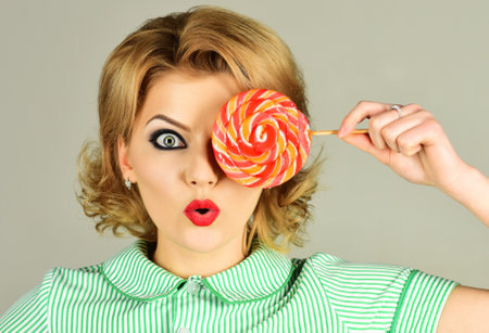 Sexy woman with colourful lollipop. Pinup girl with candy. Sweet food.の写真素材