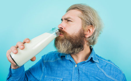 Bearded Man drink fresh milk. Lactose products. Man with bottle of milk. Lactose free milk.