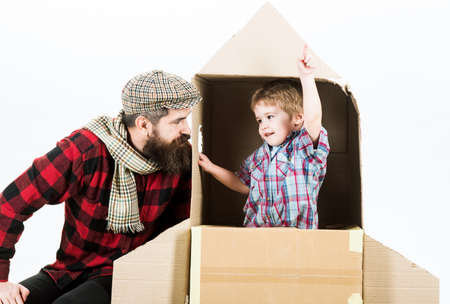 Fathers day. Parenthood. Dad and son playing with cardboard rocket. Childs dream. Cute boy playing cosmonaut.の写真素材