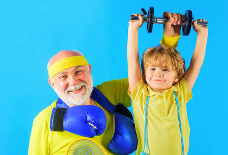 Family sport. Grandpa and son workout together. Kid boy raising dumbbell. Grandfather and child...