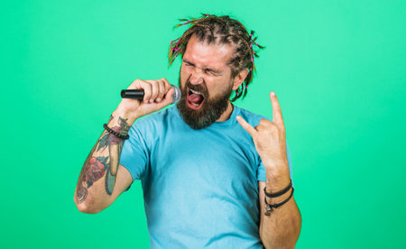 Karaoke. Bearded man singing with microphone. Studio records.の写真素材