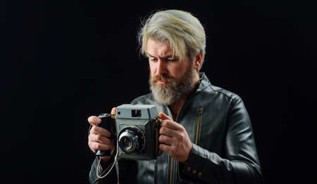 Bearded man with Vintage photo camera. Stylish photographer in leather jacket with Retro camera