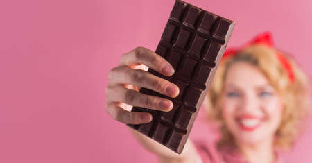 Woman Hand with Chocolate bar. Sweet food. Copy space for advertising. Selective focus