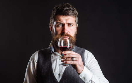 Bearded man Drinking red wine. Sommelier tasting wine in restaurant. Wine glass. Alcohol.の写真素材