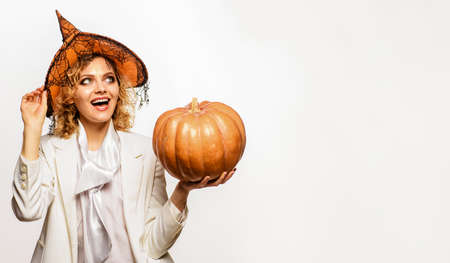 Happy Halloween. Smiling woman in witch hat with halloween pumpkin. Trick or treat. Copy space for...