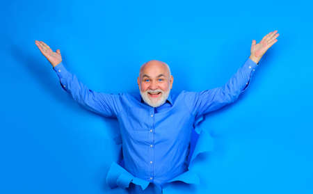 Excited bearded man making hole in paper. Advertising. Discount, sale, season sales. Black friday.の写真素材