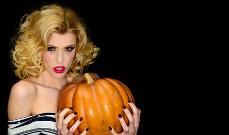 Halloween Party. Sensual girl with big pumpkin. Sexy Witch woman with Jack-o-lantern. Copy space.の写真素材