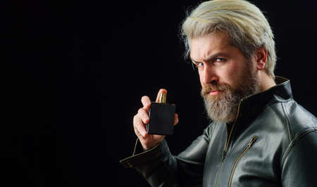 Mens cosmetics. Bearded man with Perfume or cologne bottle. Male fragrance and perfumery. Copy space.の写真素材